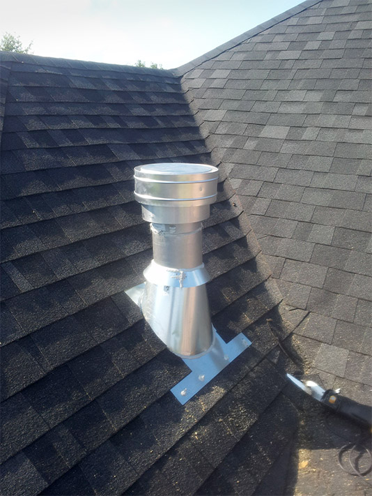 The homeowner chose to have the vent pipe exposed for this installation. Note the purpose-built flashing and lapping of the shingles over the flashing to create a watertight barrier.